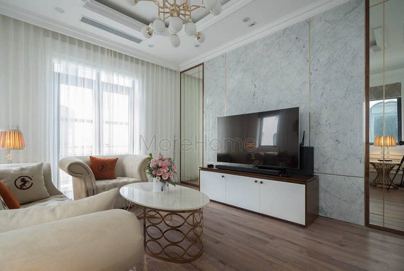 Gương dán tường khung gỗ chạm trần giúp mở rộng diện tích phòng khách
